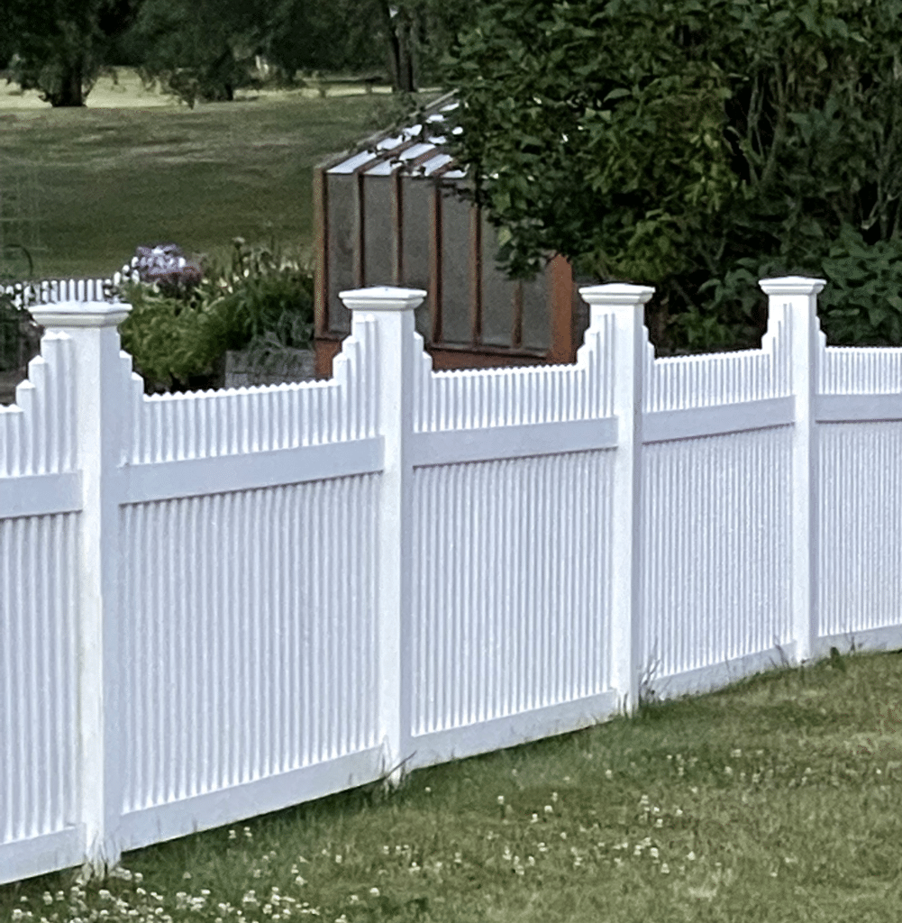 Example of a white vinyl fence surrounding a backyard