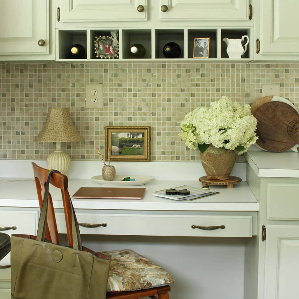 A kitchen desk with cabinets above it