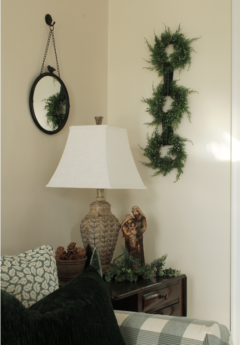 Three mini wreaths attached with ribbon to make a Christmas wall hanging