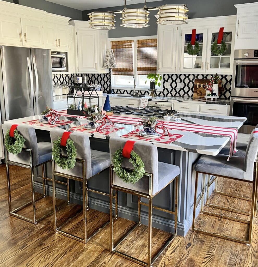 A white kitchen with a large island decorated for Christmas