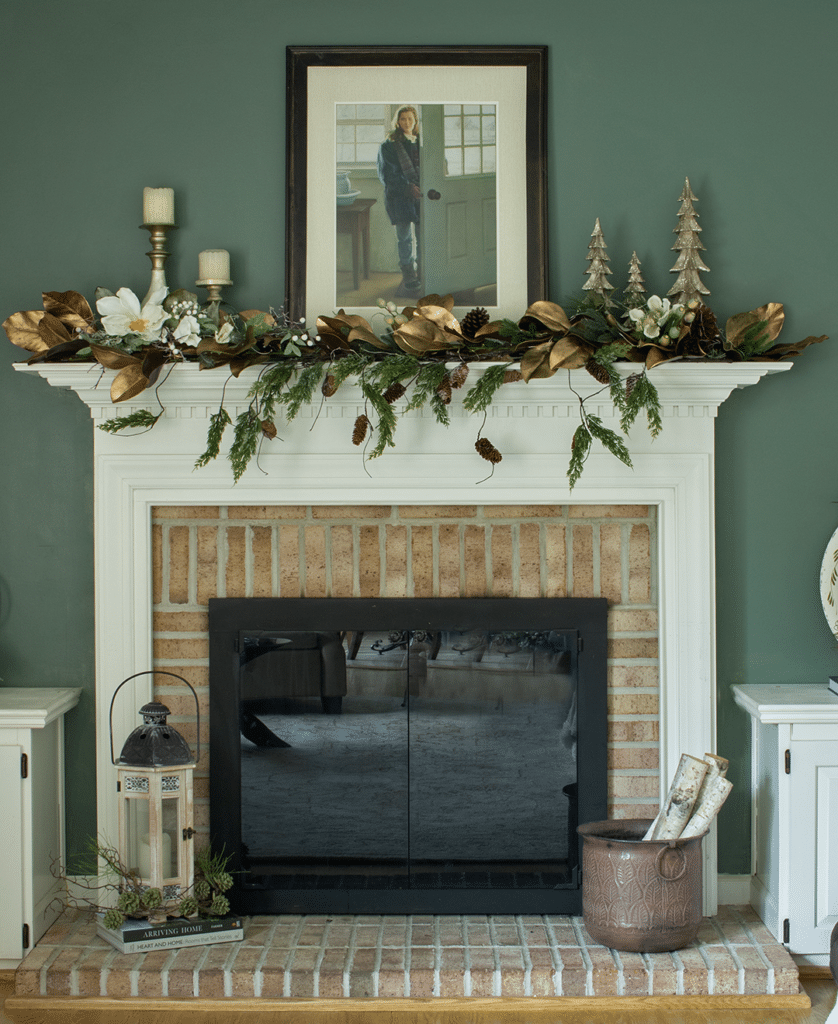 A Christmas mantel decorated with gold magnolia leaves and gold trees
