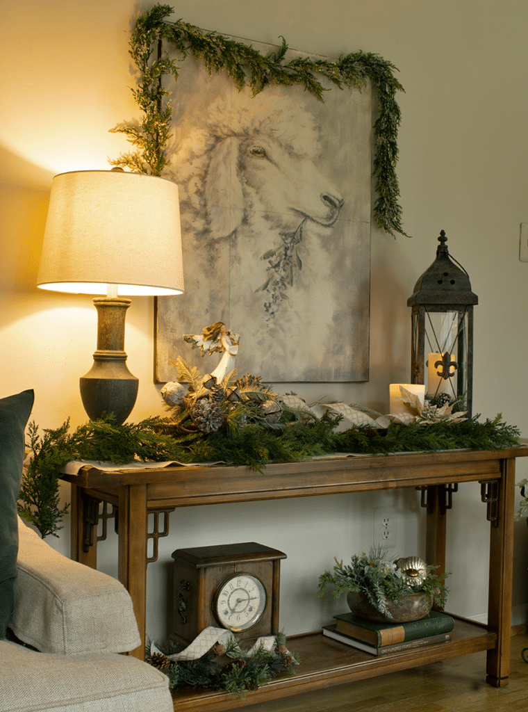 sofa table decorated for Christmas backed by large sheep painting
