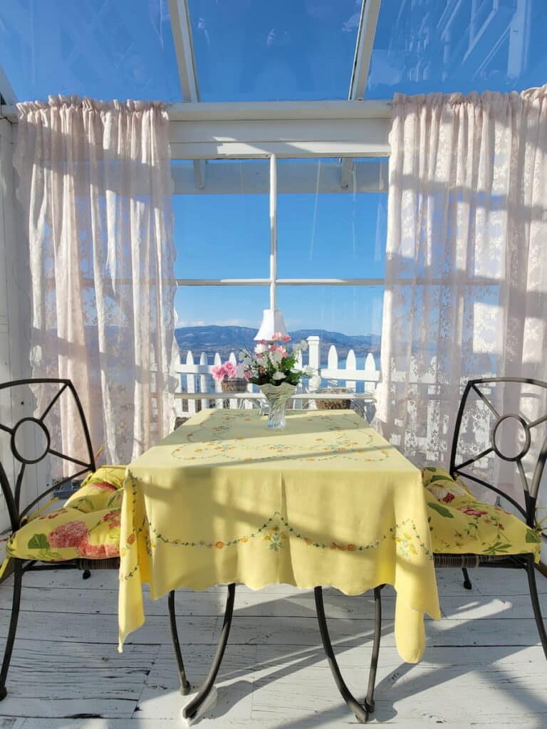 A dining table in an outdoor setting with a yellow tablecloth