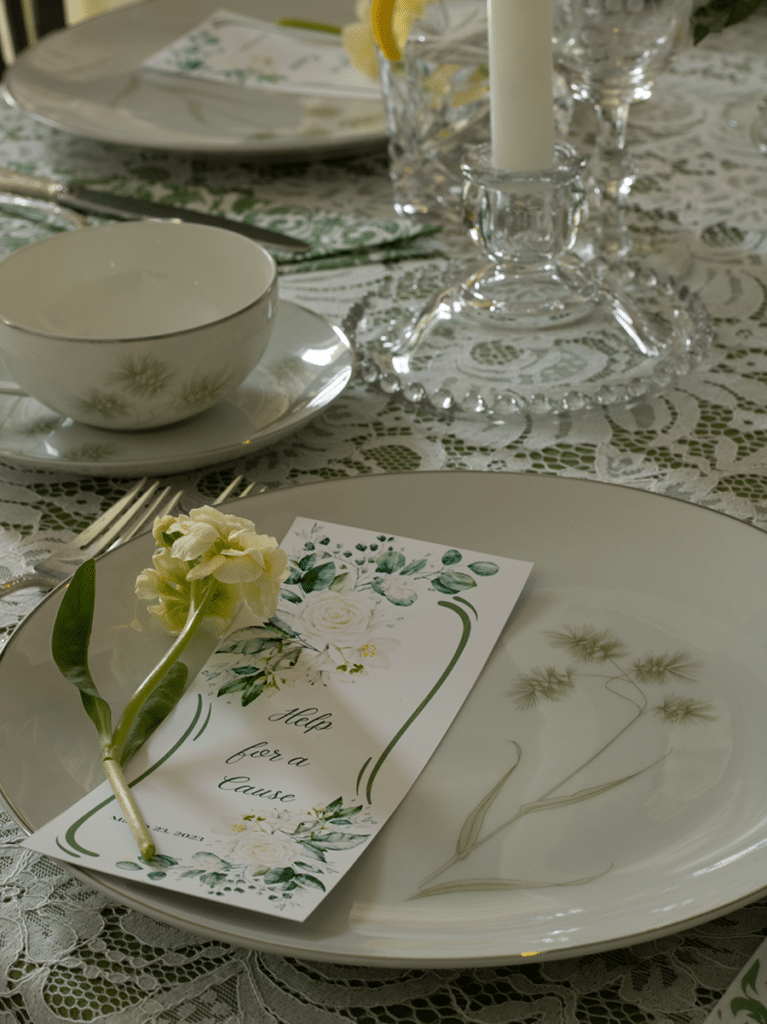 Close up of a place setting featuring a 1960s plate topped with a bookmark as a favor and a flower on top of the bookmark