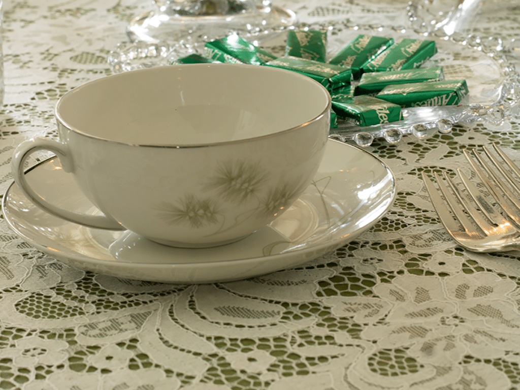 A tea cup on a lace tablecloth