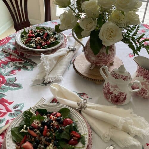 Spinach salad with strawberries and blueberries and topped with raspberry vinaigrette dressing