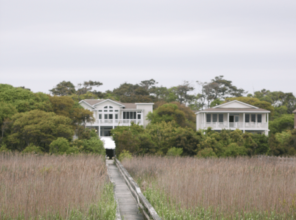 Two beach houses with a long boardwalk in front