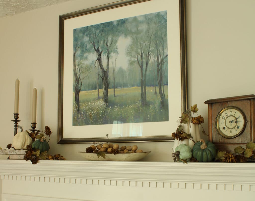 An example of green and white pumpkins on a mantel mixed with pops of brown for fall.