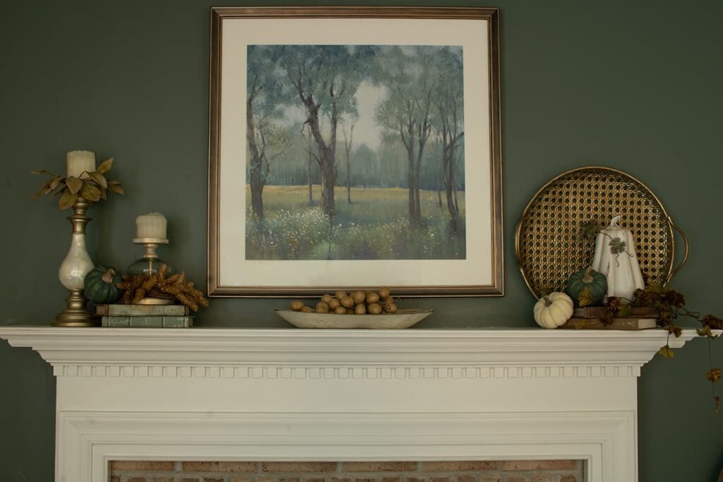 A fall mantel decorated in shades of green and brown.