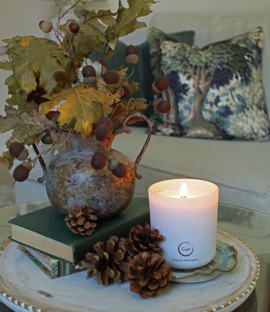 An example of how to use pine cones to style a fall scented candle.