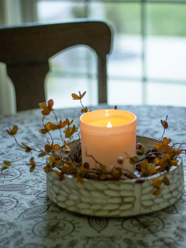 A candle in a carved wooden bowl.