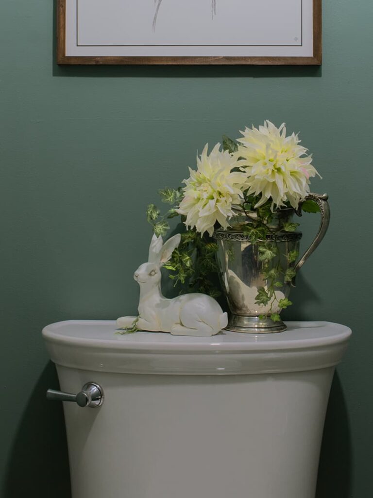 The back of a toilet decorated with flowers.