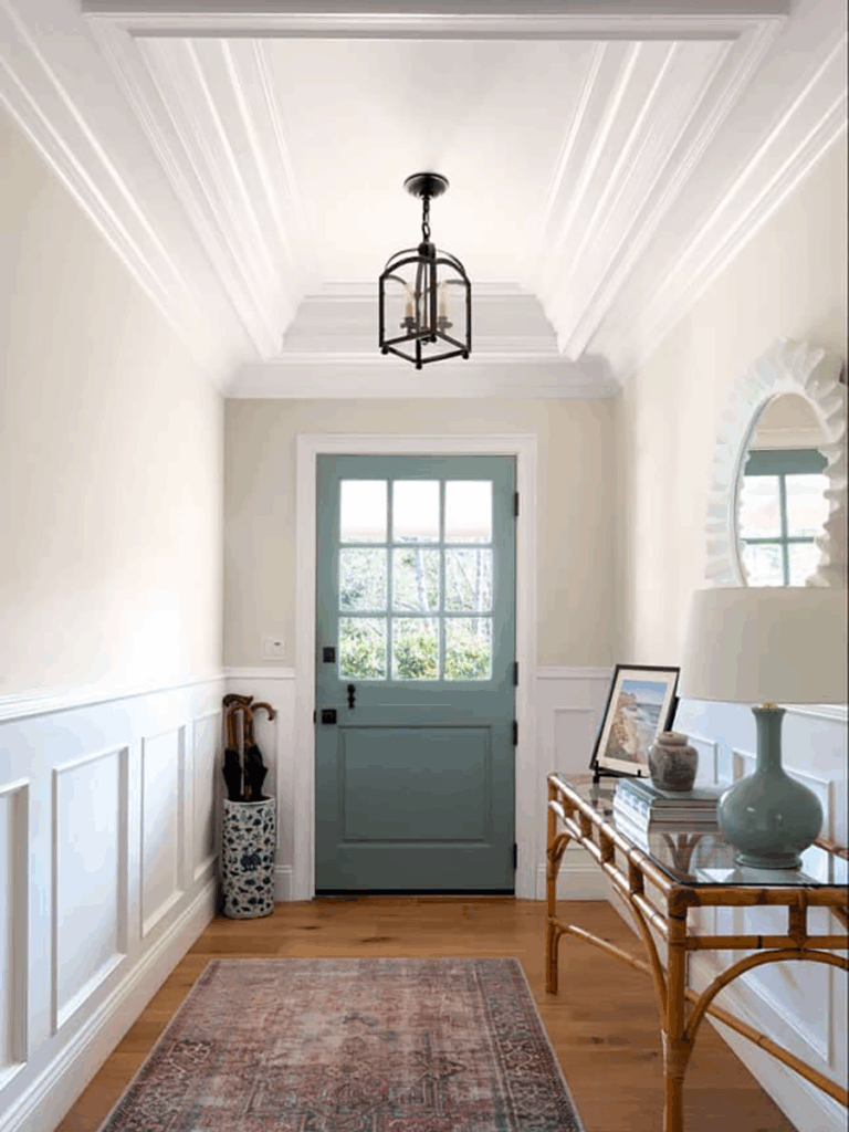 A foyer with the interior side of the front door painted Farrow and Ball Oval Room Blue