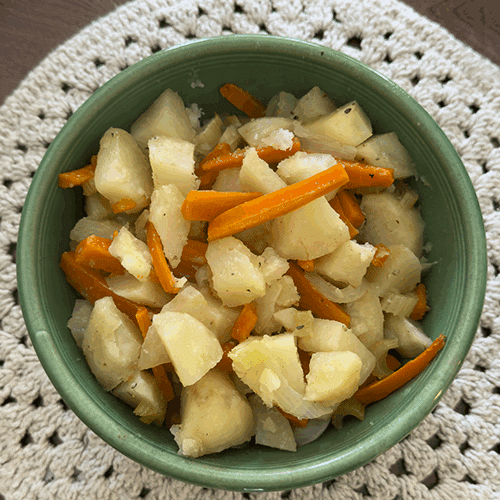 A bowl of roasted potatoes and carrots that were made on the grill