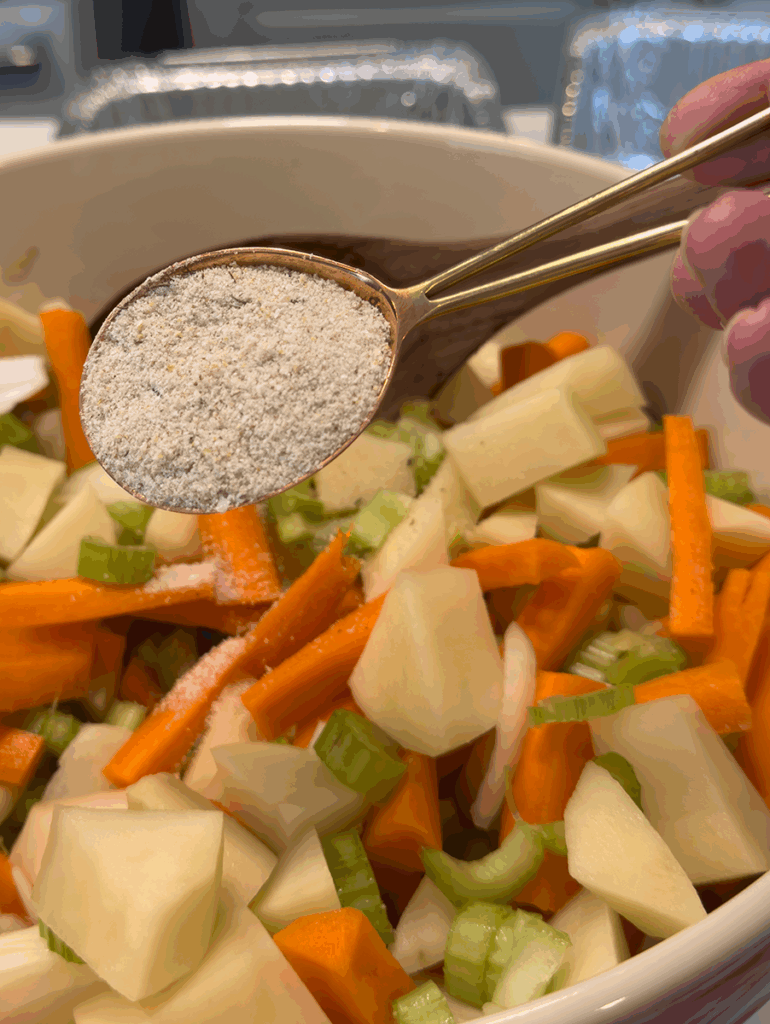 A five spice blend being added to root vegetables
