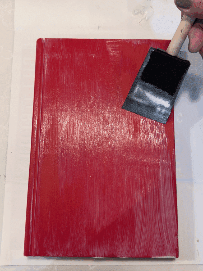 A book being covered with mod podge